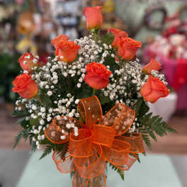 Orange roses with baby's breath and an orange ribbon bow