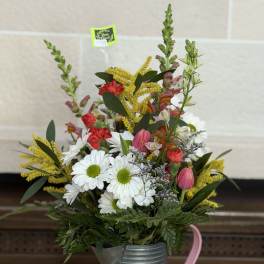 Mixed bouquet in a metal watering can with white daisies and pink blooms