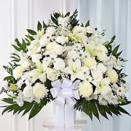 White floral standing spray with a ribbon on a pedestal