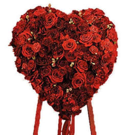 Heart-shaped arrangement of red roses with hanging ribbons