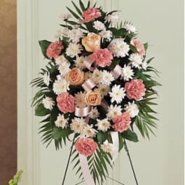 Standing floral spray with pink and white flowers on a black easel