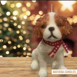 Dog-shaped candle with a red scarf on a wooden surface