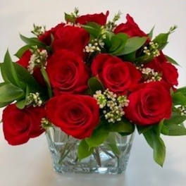 Red roses arranged in a clear glass vase