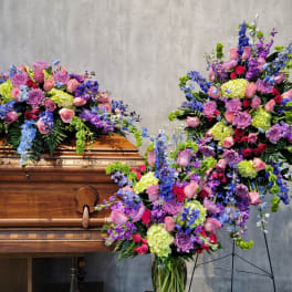 Large floral sprays on and beside a wooden casket