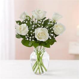 White roses arranged in a clear glass vase