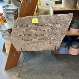 Stone plaque with an engraved memorial quote on a metal stand