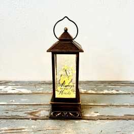 Decorative lantern with yellow flowers and the words "Always in our Hearts"