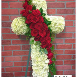 Cross-shaped floral arrangement with red roses and white hydrangeas