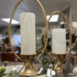 Two gold candle holders with white pillar candles