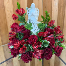 Red rose arrangement with a white angel figurine centerpiece