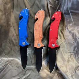 Three folding knives with blue, wood-tone, and red handles on fabric