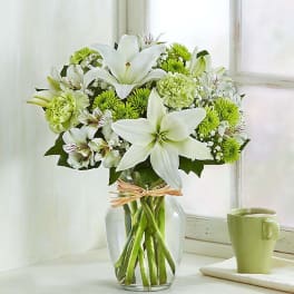 White lilies and green chrysanthemums in a glass vase