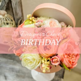 Pastel bouquet of roses and ranunculus in a round pink box