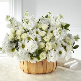 White roses and daisies arranged in a wooden basket