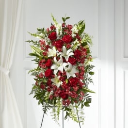 Standing floral spray with red roses, white lilies, and pink accents