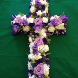 Purple and white floral cross arranged in a cross shape