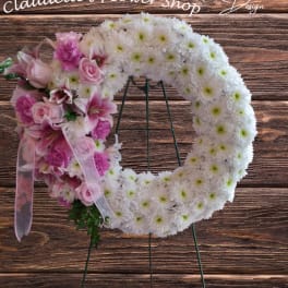 Heart-shaped floral wreath with pink and white flowers on a stand