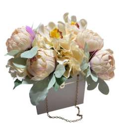 Cream and blush floral arrangement in a gift bag with a chain handle