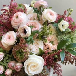Bouquet of pale pink and white flowers with green accents