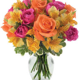 Bouquet of orange and pink roses with yellow alstroemeria in a glass vase