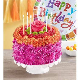 Pink and orange flower cake with candles and a birthday balloon