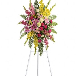 Tall standing floral spray with pink, yellow, and white flowers on a metal easel