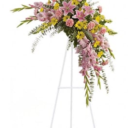 Pink and yellow floral spray on a white easel stand