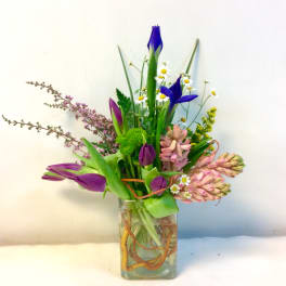 Mixed bouquet in a clear glass vase with purple and pink blooms