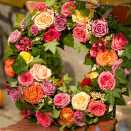 Heart-shaped wreath of multicolored roses with ivy