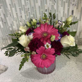 Pink gerbera daisies and white roses in a pink vase