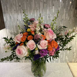 Mixed bouquet of pink and orange roses in a glass vase