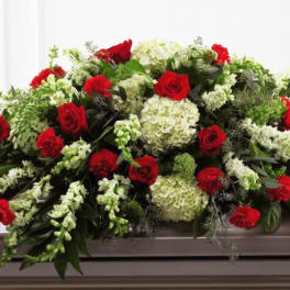 Red roses and white flowers arranged on a casket