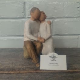 Wooden figurine of a seated couple embracing, with an anniversary card