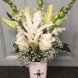 White lilies and roses in a pink vase with baby's breath