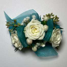 White rose corsage with teal ribbon and small white berries