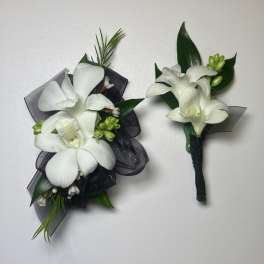 White orchid corsage and boutonniere with black ribbon accents