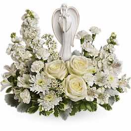 White floral sympathy arrangement with an angel figurine