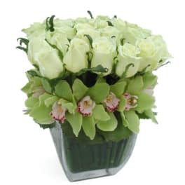 White roses and green orchids in a glass vase
