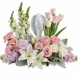 Pink and white floral arrangement with a silver angel figurine