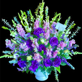 Purple and pink floral arrangement in a white vase