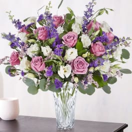 Pink roses and white blooms in a clear glass vase