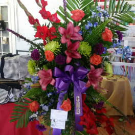 Large standing floral spray with red, pink, purple, and blue flowers