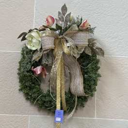 Floral wreath with pink and white flowers and a gold ribbon bow