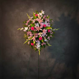 Standing floral spray with pink and lavender blooms on an easel