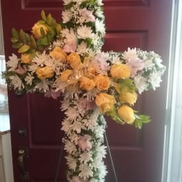 Floral cross arrangement with yellow roses and white daisies