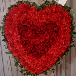 Heart-shaped red rose and carnation standing spray on an easel