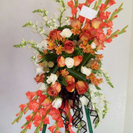 Tall floral standing spray with orange and white roses and red gladiolus