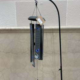 Gray memorial wind chime with blue butterflies and white floral accents hanging from a tall black metal stand.