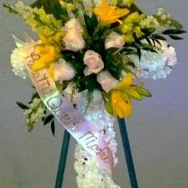 Standing floral spray with yellow and white flowers on an easel