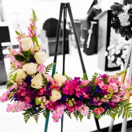 Colorful floral arrangement on an easel with roses and pink blooms